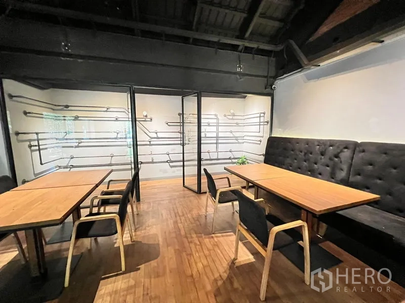 Retail Space for rent in Bangkok - Cozy dining nook with banquette seating, wood tables and a glass partition.