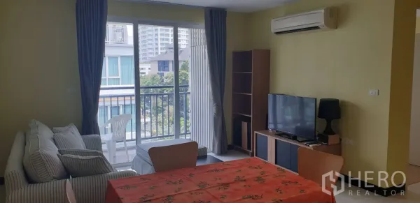 公寓 出租在Khlong Toei, Bangkok - 开放式起居区，电视柜与置物架，空调，通向阳台的玻璃门。
