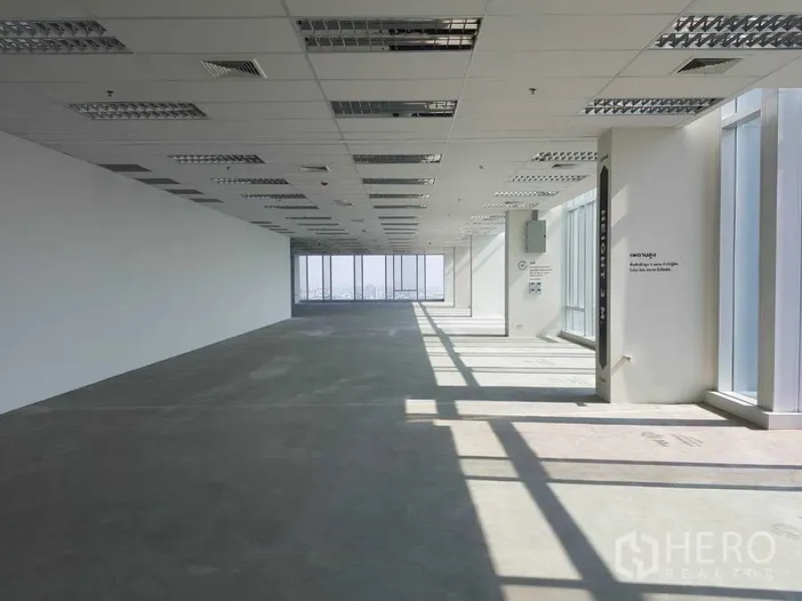 Office Space for rent - Spacious shell office area with grid ceiling and abundant daylight from full-height glazing.