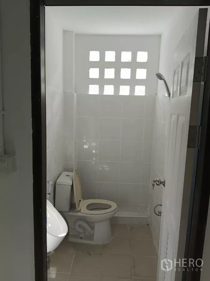 Warehouse for rent in Bang Phli, Samut Prakan - Second restroom with ventilation blocks, toilet and hand shower.