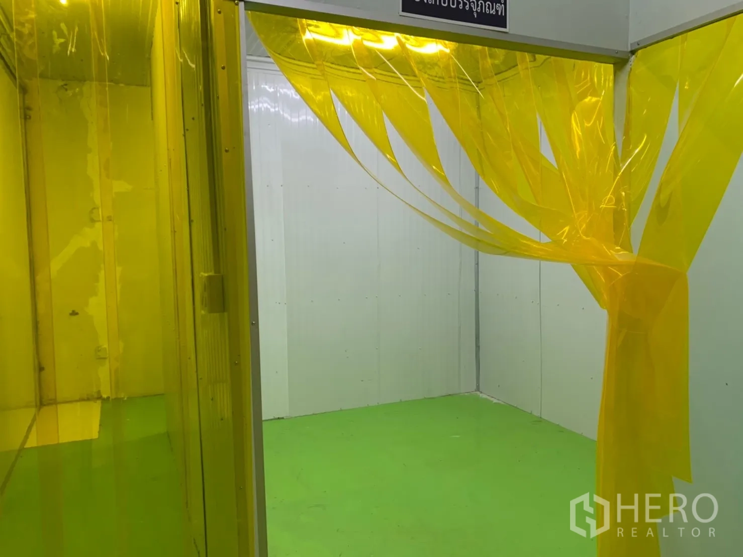 Factory for rent in Khlong Luang, Pathum Thani - Cleanroom area with yellow PVC strip curtains, green epoxy floor, and white panel walls.