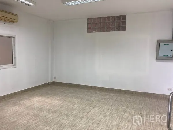 Warehouse for rent in Bang Phli, Samut Prakan - Air-conditioned office room with tiled floors, fluorescent lights and a small window.