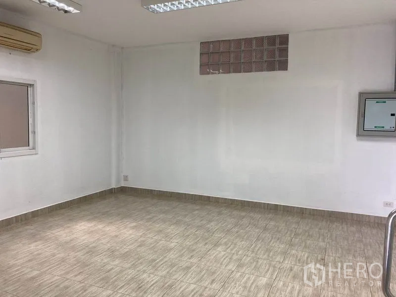 Warehouse for rent in Bang Phli, Samut Prakan - Air-conditioned office room with tiled floors, fluorescent lights and a small window.