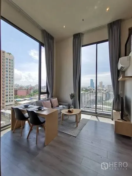 公寓 出租在Phaya Thai, Bangkok - 客厅设超大窗与阳台门，城市天际线景观与小餐桌。