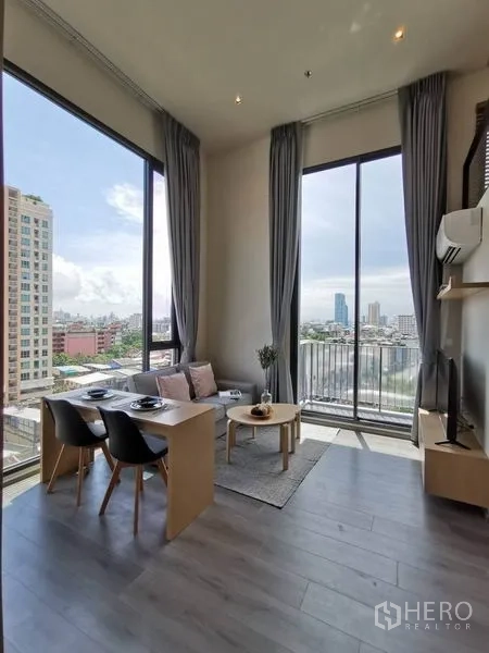 公寓 出租在Phaya Thai, Bangkok - 客厅设超大窗与阳台门，城市天际线景观与小餐桌。