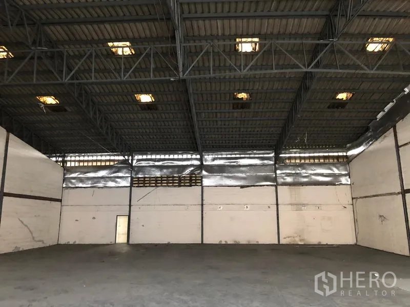 Warehouse for rent in Bang Phli, Samut Prakan - Open-plan warehouse space showing high ceiling, skylights, and ventilation along the eaves.