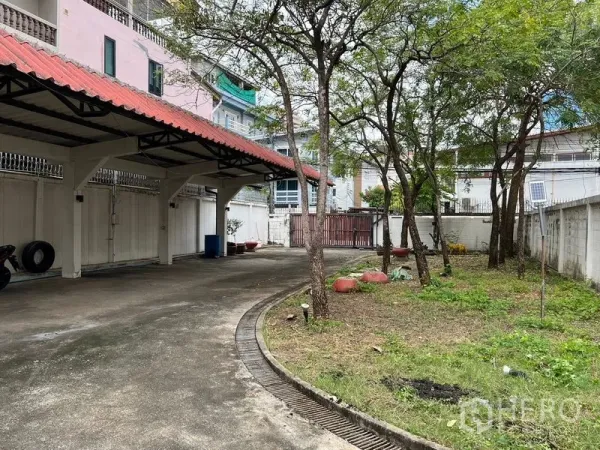 บ้าน ให้เช่าในSathon, Bangkok - โรงจอดรถหลังคากระเบื้องสีแดงข้างสนามหญ้าและต้นไม้ในรั้วบ้าน