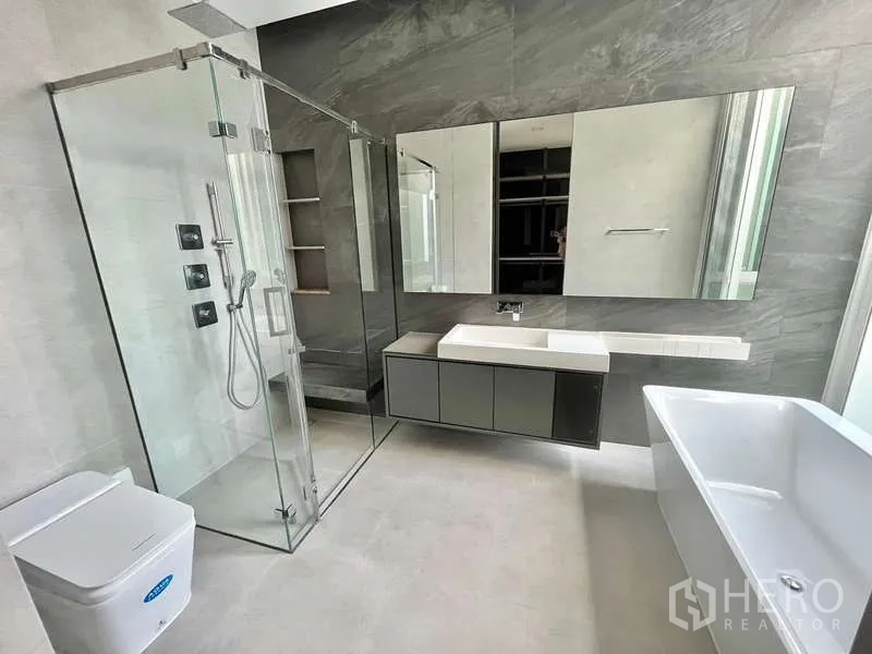Detached House for rent or sale in Bang Phli, Samut Prakan - Modern bathroom with a glass shower enclosure, soaking tub and a large mirrored vanity.