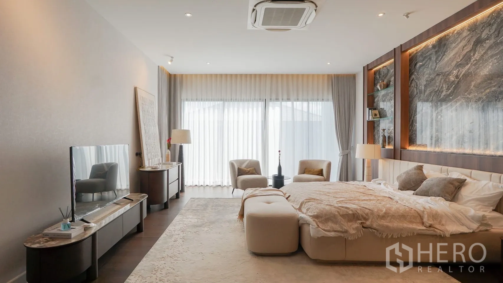 Detached House for rent or sale in Bang Kapi, Bangkok - Secondary bedroom with upholstered bed, bedside tables and accent chair.