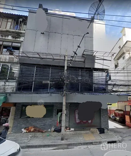 Shophouse for rent in Khlong Toei, Bangkok - Street-front multi-storey shophouse exterior in Khlong Toei, Bangkok with wide frontage, roll-up shutter and upper-floor facade near mass transit.