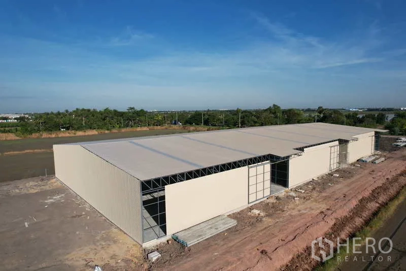 Warehouse for rent or sale in Pak Kret, Nonthaburi - Oblique drone shot of the warehouse showing multiple entry bays and wide frontage.