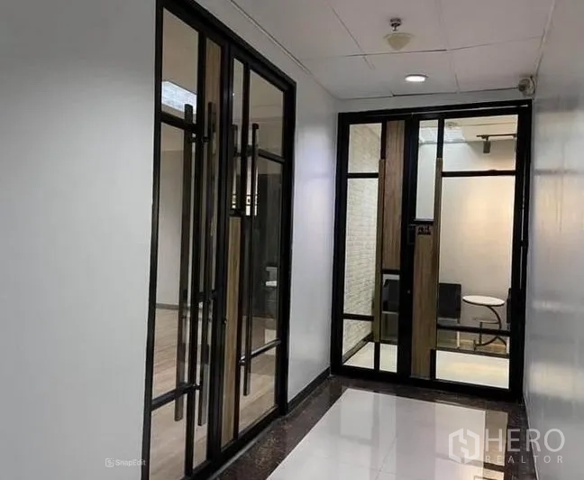 Office Space for rent in Bang Na, Bangkok - Modern office entry with black-framed glass double doors and bright corridor in Bang Na.