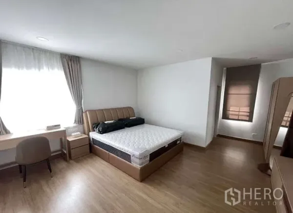 บ้าน ให้เช่าในBang Phli, Samut Prakan - ห้องนอนกว้างพร้อมเตียงบุนวม โต๊ะทำงาน หน้าต่างบานใหญ่ และพื้นไม้