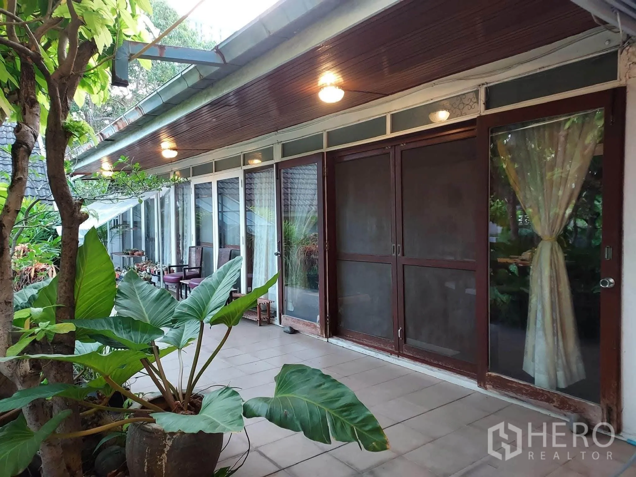บ้านเดี่ยว for rent or sale in Mueang Samut Prakan, Samut Prakan - เฉลียงยาวหน้าบ้านพร้อมประตูกระจกบานเลื่อนและไม้กระถาง