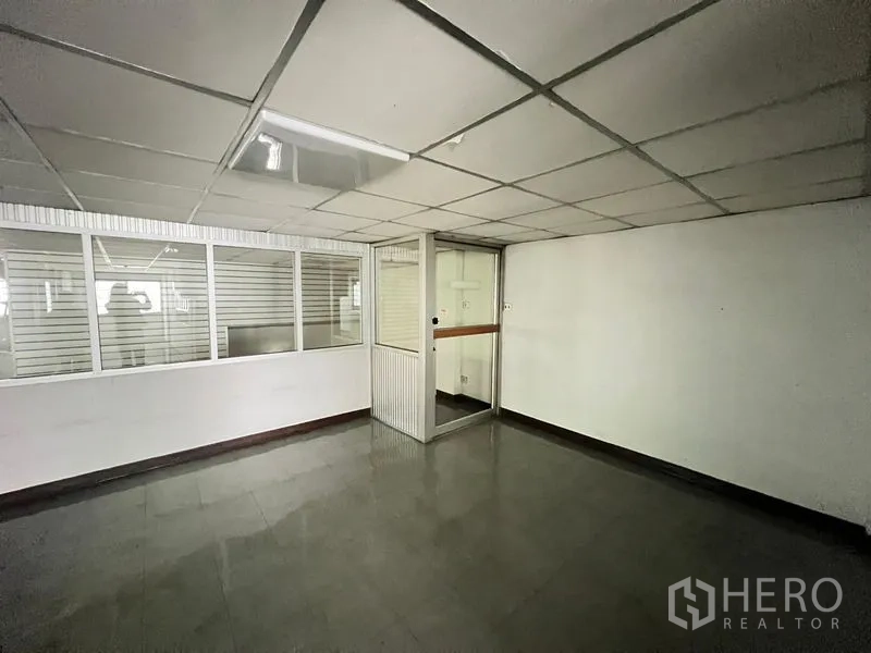 Shophouse for sale - Compact office room with glass partitions and tiled flooring.