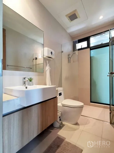 Condominium for rent in Sathon, Bangkok - Bathroom with glass shower enclosure, wall-hung vanity and bright tiles.