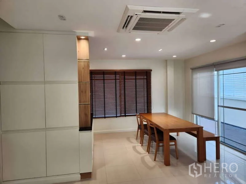 独立式住宅 出租在Sathon, Bangkok - 餐区配木质餐桌、百叶窗与大窗户。