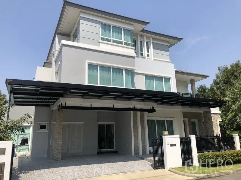 Detached House for rent or sale in Saphan Sung, Bangkok - Three-storey modern detached house facade with covered carport and gated entry at Grand Bangkok Boulevard.