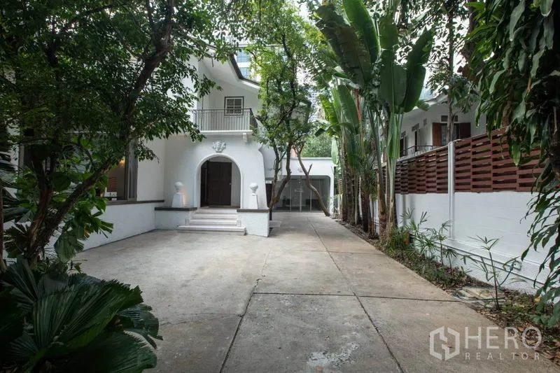 独立式住宅 出租在Pathum Wan, Bangkok - 曼谷伦披尼树荫下的白色独栋别墅，拱形门厅与车道。