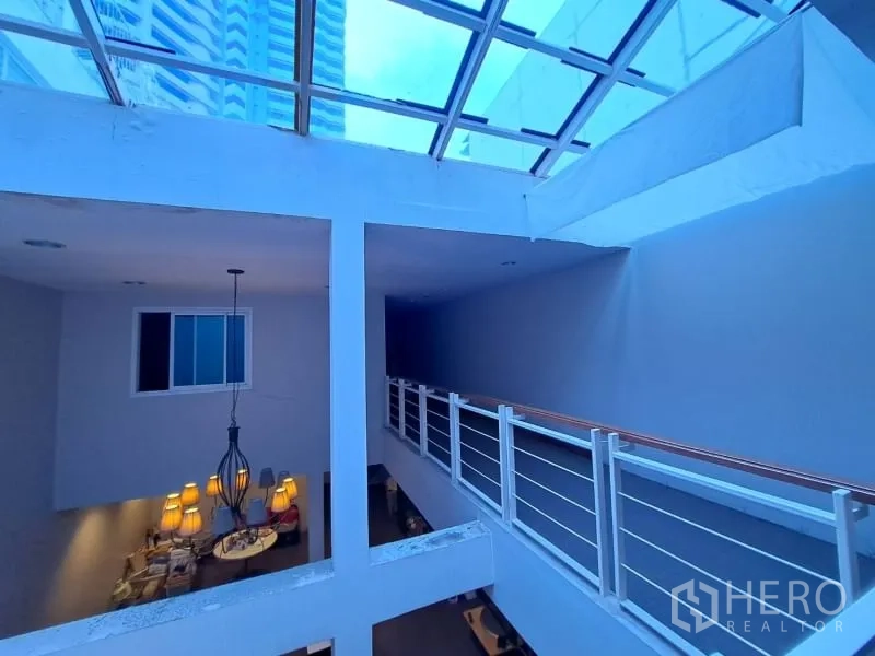 Shophouse for rent in Watthana, Bangkok - Upper-floor corridor beneath a large skylight with metal handrails.