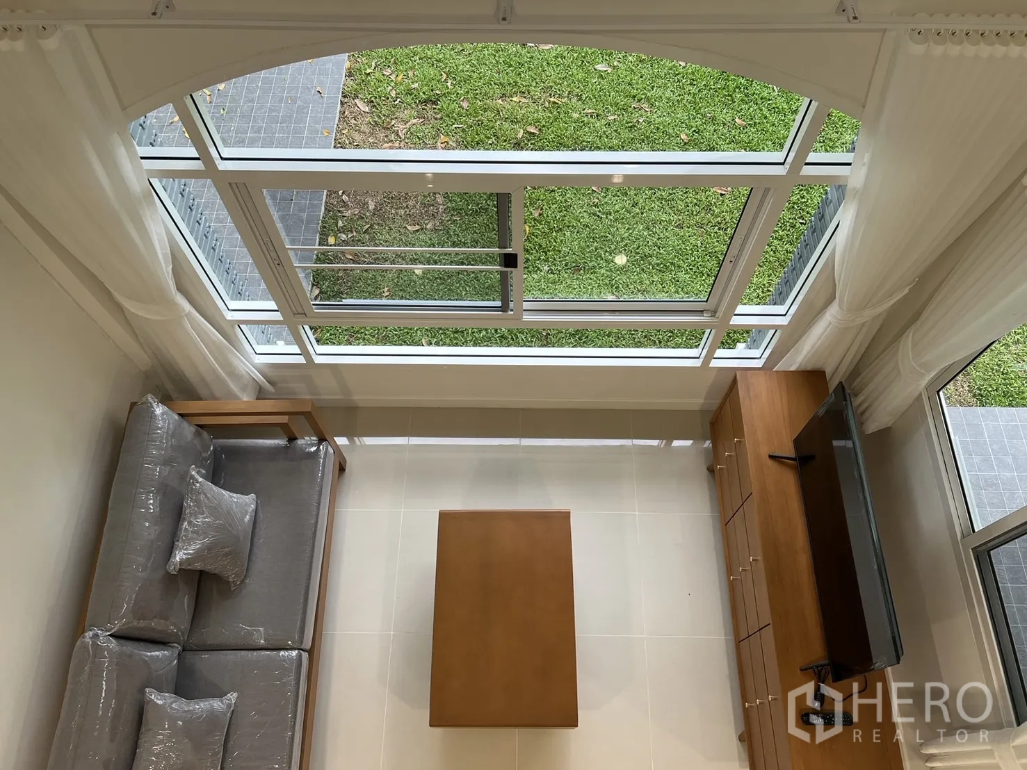Detached House for rent in Saphan Sung, Bangkok - Top view of double-height window and garden from the mezzanine.
