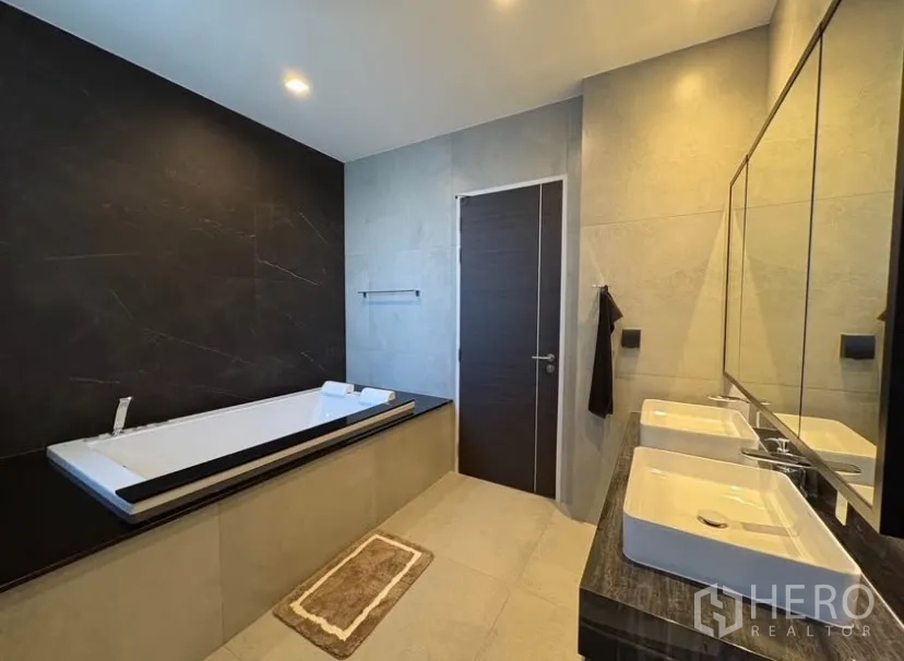 บ้านเดี่ยว for rent in Suan Luang, Bangkok - ห้องน้ำหรูมีอ่างอาบน้ำยาวและอ่างล้างหน้าคู่ ผนังสีดำตัดเทา