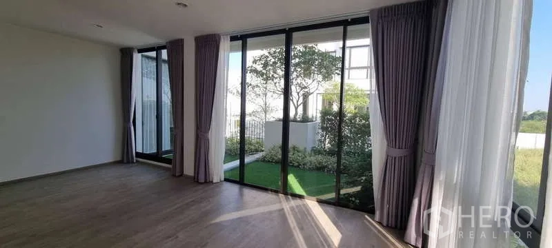 独立式住宅 出租在Lat Krabang, Bangkok - 卧室落地玻璃，通向小型花园露台与绿意。