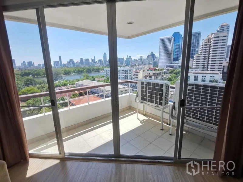 Condominium for rent in Khlong Toei, Bangkok - Private balcony through sliding glass doors with city and park views, plus AC units.