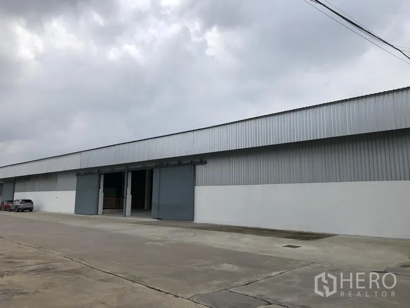 คลังสินค้า ให้เช่าในNonthaburi - ด้านข้างอาคารโกดังผนังเมทัลชีทยาวมีหลายช่องประตูติดกับถนนภายในโครงการ