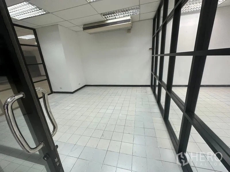 Office Space for rent in Din Daeng, Bangkok - Private room with glass wall, tiled floor and ceiling-mounted air conditioner.