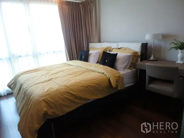 Condominium for rent in Watthana, Bangkok - Bright master bedroom with double bed, floor-to-ceiling windows, warm curtains and a work desk.