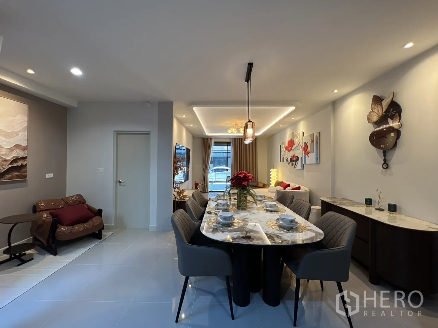 ทาวน์เฮาส์ for rent in Bang Phli, Samut Prakan - ห้องรับประทานอาหารยาวพร้อมโต๊ะหินอ่อนสำหรับหกที่นั่ง มองไปยังโซนนั่งเล่นและหน้าต่าง