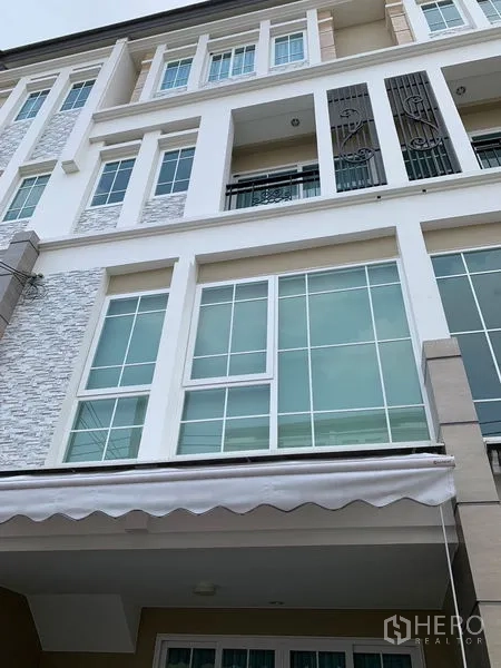 联排别墅 出租在Bang Na, Bangkok - 多层联排外立面，大框格窗与小阳台