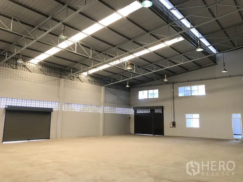 Factory for rent in Lat Lum Kaeo, Pathum Thani - Warehouse interior showing skylight panels and multiple roller shutters