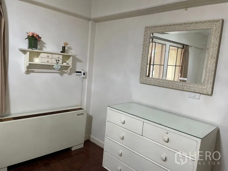 Apartment for rent in Watthana, Bangkok - Room corner featuring a white dresser, wall mirror and decorative shelf.