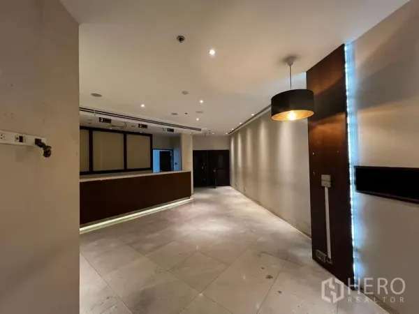 Retail Space for rent - Open-plan shop area featuring a service counter, pendant lighting, and neutral walls.