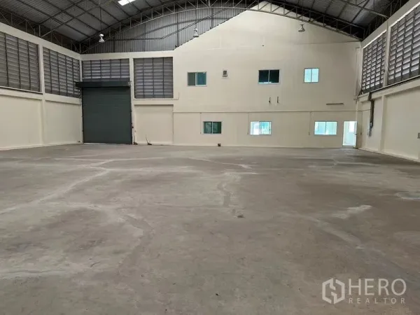 Warehouse for rent in Mueang Samut Sakhon, Samut Sakhon - Warehouse bay with large roller shutter door and attached two-storey office block with windows.