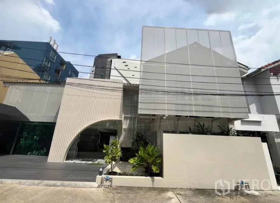 Home Office for rent in Bangkok - Renovated two‑storey home office exterior with perforated screen façade, driveway and planting in Pathum Wan, Bangkok.