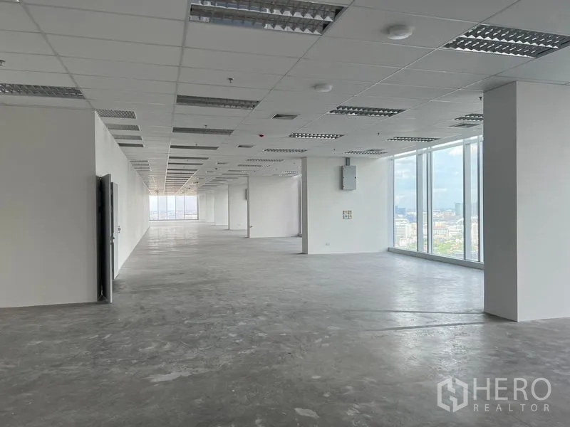 Office Space for rent - Long, column-free office floor with drop ceiling lighting and large glazing.
