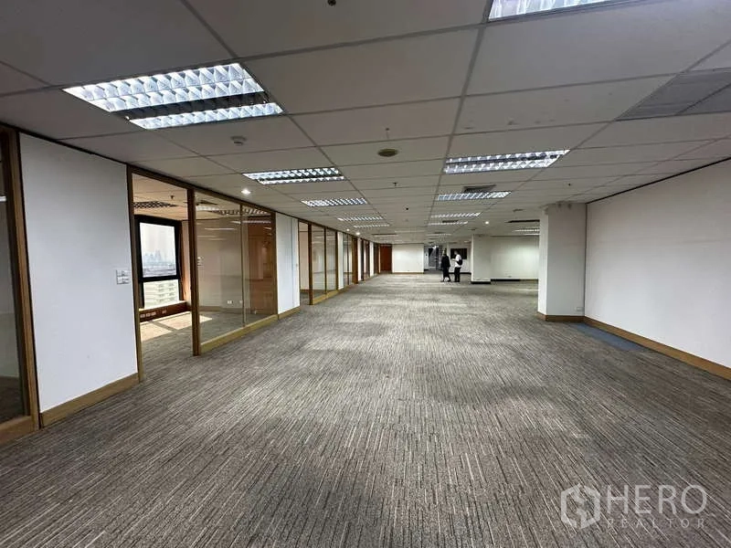 Office Space for rent in Khlong Toei, Bangkok - Spacious open-plan office floor with carpet tiles, drop ceiling and glass-partitioned rooms.