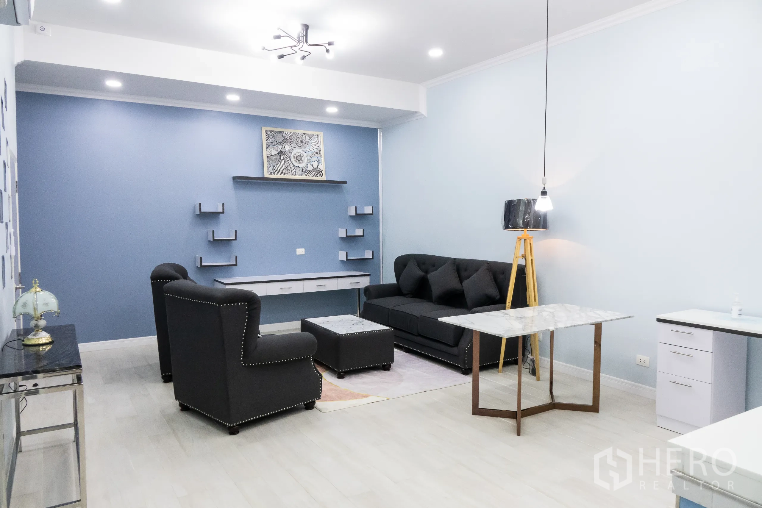 Condominium for rent or sale in Khlong Toei, Bangkok - Lounge view with designer tripod lamp, marble dining table and plush seating.