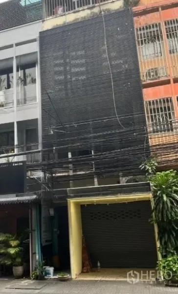 Shophouse for rent in Khlong Toei, Bangkok - Another view of the shophouse exterior showing the dark facade and closed shutter.