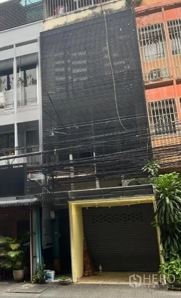 Shophouse for rent in Khlong Toei, Bangkok - Another view of the shophouse exterior showing the dark facade and closed shutter.