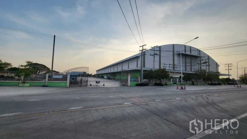 โรงงาน ให้เช่าในSai Noi, Nonthaburi - มุมอาคารภายนอกพร้อมรั้ว ทางเข้า และเสาไฟฟ้าตามแนวถนน