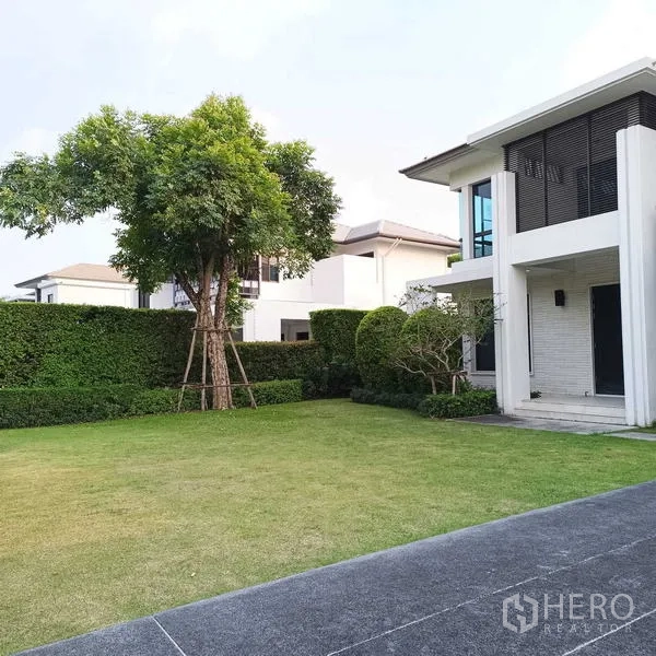 独立式住宅 出租或出售在Mueang Nonthaburi, Nonthaburi - 房屋侧院景观花园，成树与整齐绿篱。