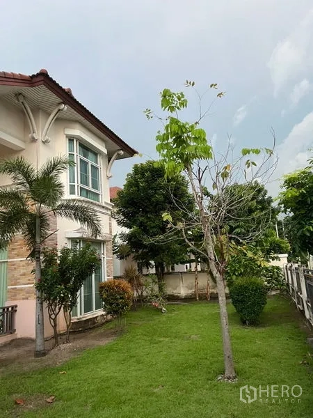 Detached House for rent or sale in Lat Krabang, Bangkok - Side garden with trees and shrubs beside the facade of the detached house.