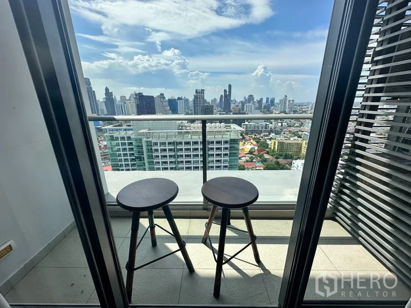公寓 出售在Watthana, Bangkok - 私人阳台，两张吧凳俯瞰曼谷天际线