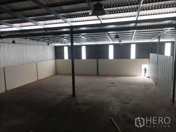 工厂 for rent in Ban Phaeo, Samut Sakhon - 宽敞仓库空间，墙面竖向采光窗与侧门可见。