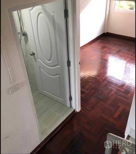 带办公室的家 出租或出售在Watthana, Bangkok - 卧室带光亮木地板，连接带淋浴的套内卫生间与窗户。