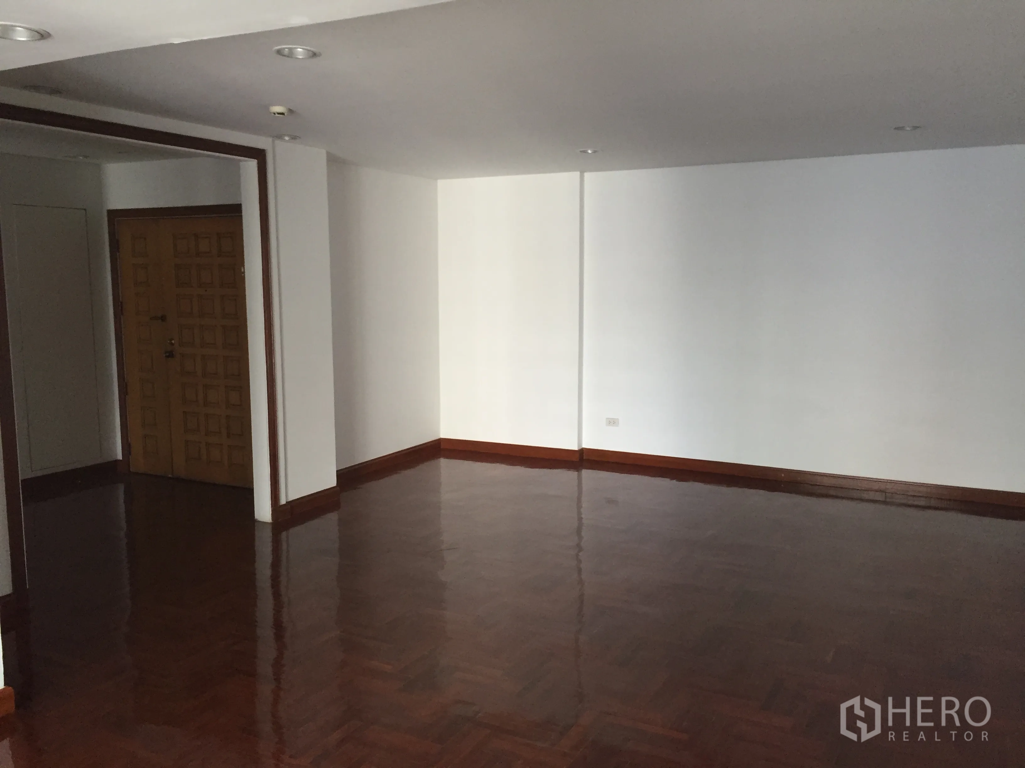 公寓 出租在Pathum Wan, Bangkok - 大型起居区，嵌入式照明，抛光木地板与入户门。